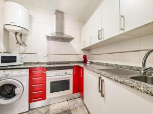 una cucina con mobili rossi e un lavandino di Avenida Guillermo Reina 1ºB a Huércal-Overa