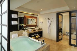 
a bathroom with a tub and a sink at Paradisus Playa del Carmen All Inclusive in Playa del Carmen
