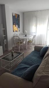 ein Wohnzimmer mit einem Sofa und einem Tisch mit Stühlen in der Unterkunft MyHome in Noja