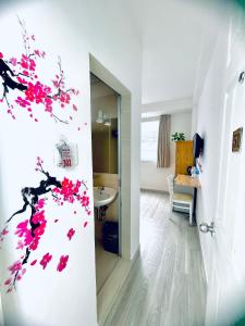 a room with a bathroom with pink flowers on the wall at Marieline Hotel Pham Ngu Lao in Ho Chi Minh City
