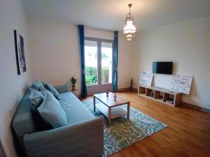 a living room with a couch and a table at Maison clarette in Carhaix-Plouguer