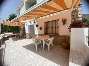 a patio with a table and chairs and a building at ApartamentoS Rosa in Arroyo Frio