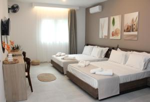 two beds in a hotel room with white towels on them at UrbanBay Hotel & Spa in Kavala