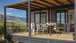 a house with a deck with a table and chairs at Terra Park SpiritoS - Luxury mobile house Ina in Kolan