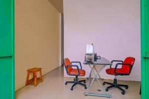 a room with three chairs and a table with a computer at Super OYO 92664 Cemara Koja Residence Syariah in Jakarta