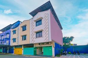 a building with colorful doors in a street at Super OYO 92664 Cemara Koja Residence Syariah in Jakarta