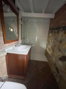 a bathroom with a sink and a stone wall at Posada El Valle - Only Adults in Suances