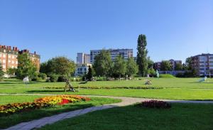 a park with flowers and buildings in the background at M&M Apartment in Velika Gorica