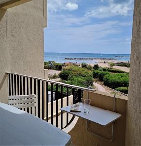 balcón con mesa y vistas a la playa en Front de plage en Palavas-les-Flots