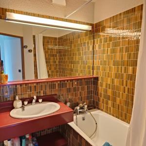 La salle de bains est pourvue d'un lavabo, d'une baignoire et d'un miroir. dans l'établissement Front de plage, à Palavas-les-Flots