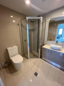 uma casa de banho com um WC, um chuveiro e um lavatório. em Kim on Smith, Darwin City em Darwin