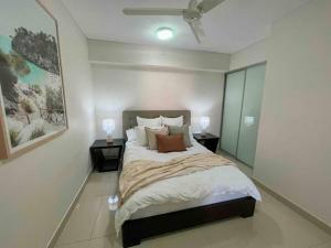 a bedroom with a large bed with two night stands at Kim on Smith, Darwin City in Darwin