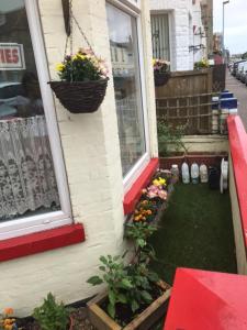 a house with flowers on the side of it at Holland House in Great Yarmouth