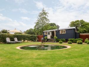 una caravana pequeña en un jardín con un estanque pequeño en Utopia, en Harleston