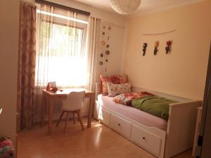 1 dormitorio con cama, escritorio y ventana en Traumapartment Pöstlingberg, reservierter Parkplatz, 4 Schlafzimmer en Linz