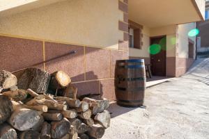 una pila di tronchi accanto a un edificio con un barile di Casa Rural La Carbonera a Cuenca