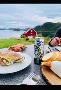 una mesa con platos de comida y una lata de cerveza en Waterfront Cottage (Fishing Opportunities!) en Ålesund