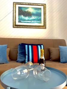 uma mesa com copos e uma garrafa num sofá em Golden House - Trilocale nel Cuore di Agrigento em Agrigento