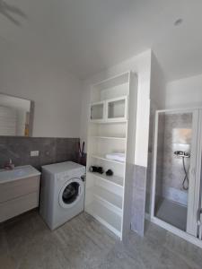 y baño con lavadora y lavamanos. en La Rosa Verde di Francavilla Marittima, en Francavilla Marittima