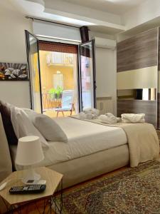 a bedroom with a large bed and a living room at Golden House - Trilocale nel Cuore di Agrigento in Agrigento