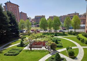 a park with a bench and bushes in a city at i cedri in Turin