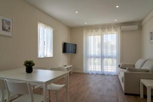 een woonkamer met een tafel en een bank bij LEGACY SUITES & APARTMENTS ALBUFEIRA AL in Albufeira