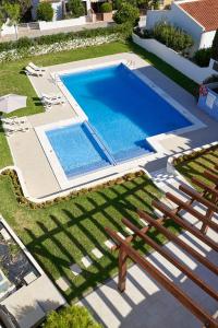 een uitzicht over een zwembad in een tuin bij LEGACY SUITES & APARTMENTS ALBUFEIRA AL in Albufeira