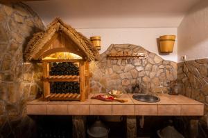 uma cozinha com um balcão com uma casa e um lavatório em Vineyard Cottage Krivic em Trebelno