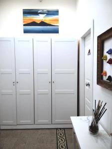 een kamer met witte kluisjes en een schilderij aan de muur bij Chiarini22 Apartments in Napels