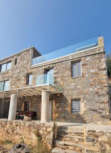 una casa in pietra con un solarium in cima di INO III Domus SWIMSPA by Amigdalokefali Elafonissi ad AmigdhalokeFálion