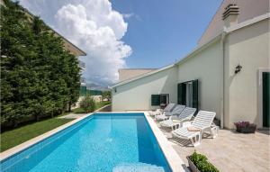 einen Pool mit Stühlen und ein Haus in der Unterkunft Gorgeous Home In Mravince With Wifi in Mravince