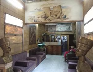 a waiting room with purple furniture and a painting on the wall at New Palace Hotel in Cairo