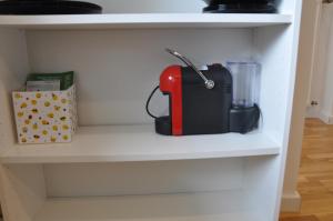 a red and black appliance sitting on a shelf at 2-Zimmer Studio mit Terrasse und Fernblick - Marburg in Marburg an der Lahn