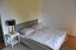 een slaapkamer met een bed en een lamp op een nachtkastje bij 2-Zimmer Studio mit Terrasse und Fernblick - Marburg in Marburg an der Lahn