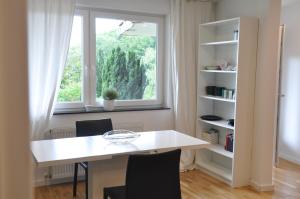 een witte tafel en stoelen in een kamer met een raam bij 2-Zimmer Studio mit Terrasse und Fernblick - Marburg in Marburg an der Lahn