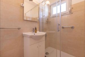 ein Badezimmer mit Waschbecken und Dusche in der Unterkunft Lovely Beach House in Aroeira by LovelyStay in Aroeira + 22 Fotos