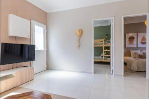 ein Wohnzimmer mit einem TV und ein Schlafzimmer in der Unterkunft Lovely Beach House in Aroeira by LovelyStay in Aroeira