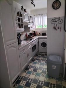 - une cuisine blanche avec un évier et un lave-linge dans l'établissement SCI LA FORGE, à Antibes