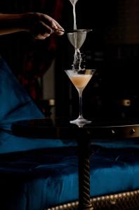 a person pouring a drink into a martini glass at Chateau Denmark London in London