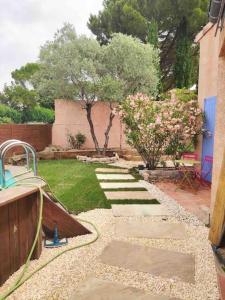 a garden with a pathway leading to a yard at Appartement duplex avec terrasse in Venelles