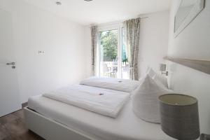 a white bedroom with a bed and a window at Black Forest Hotel Kappel-Grafenhausen in Kappel-Grafenhausen