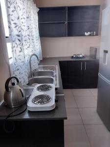 a kitchen with a stove top oven next to a sink at WAKEUP FRESH GUEST HOUSE in Johannesburg