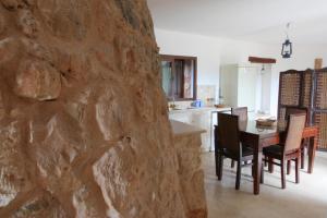 cocina y comedor con pared de piedra en trullo macchie, en Marina di Mancaversa