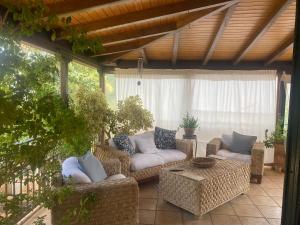 a patio with wicker couches and a table at Greek Tuscany Vasiliki's Home in Aigio