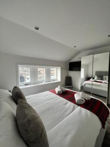 een grote witte slaapkamer met een groot bed met kussens bij Very Central, Charlotte Square, near the Castle in Edinburgh