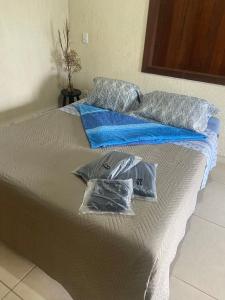 a bed with two pillows on top of it at Pousada Chales da Canastra in Vargem Bonita