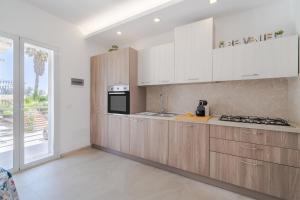 una cucina con mobili in legno e una stufa di Apt Giulia a due passi dal mare a Noto Marina