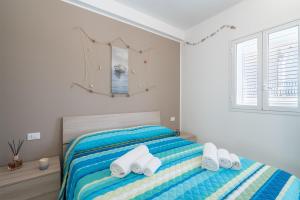 una camera da letto con un letto con asciugamani sopra di Apt Giulia a due passi dal mare a Noto Marina