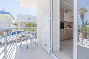 un balcone con tavolo e sedie e una cucina di Apt Giulia a due passi dal mare a Noto Marina