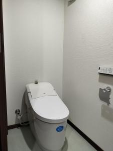 - une salle de bains avec des toilettes blanches dans une cabine dans l'établissement 古民家クルンズ, à Mino